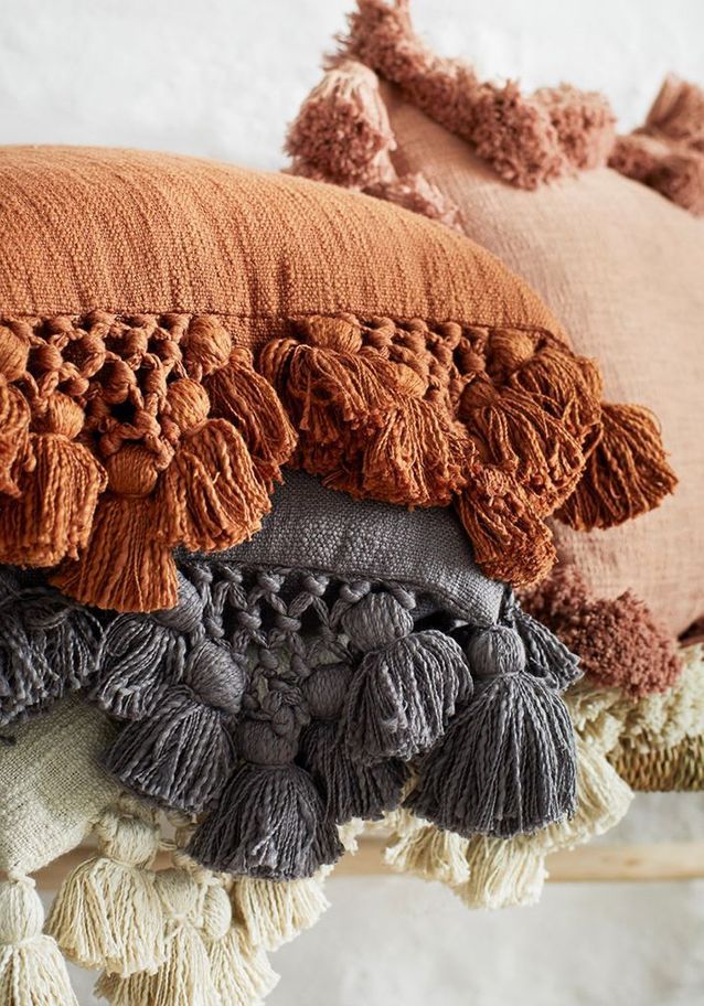 Para un ambiente bohemio, adopte cojines con pompones