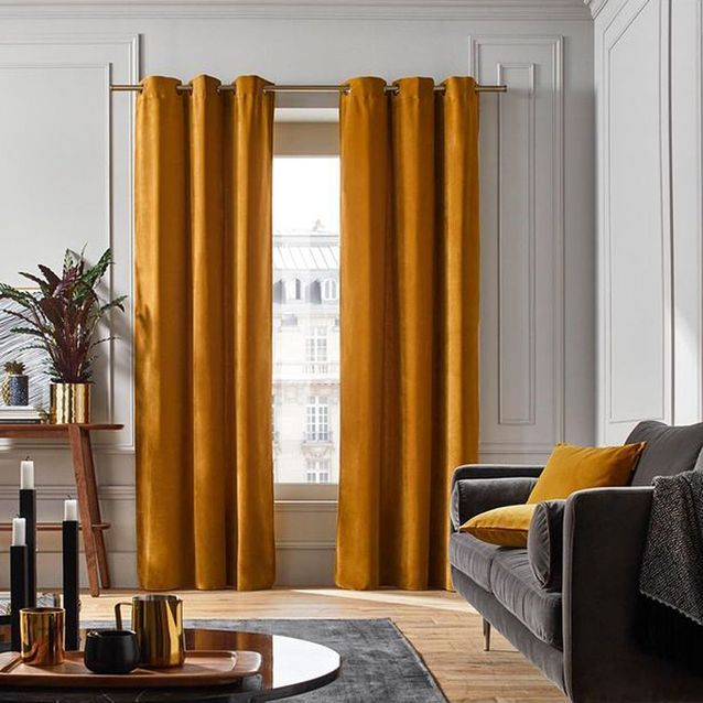 Cortinas, cojines y sofá de terciopelo para dramatizar tu interior