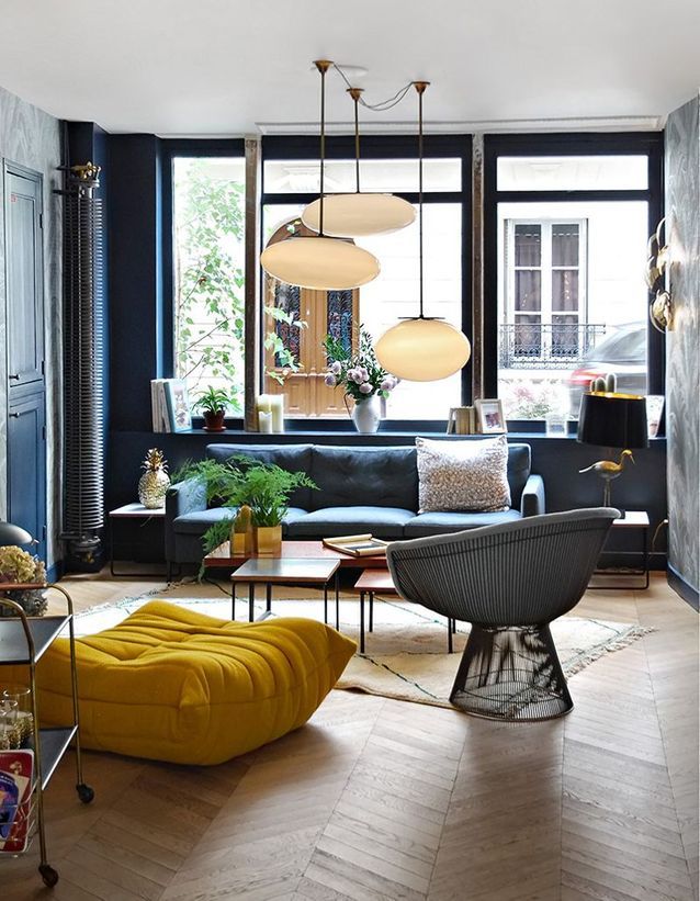 El puf Togo amarillo azafrán en un salón azul medianoche