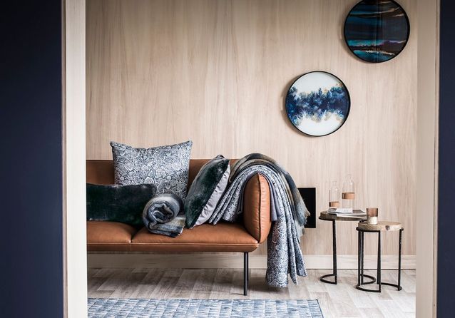 Multiplica los cuadros y las mantas para un salón acogedor